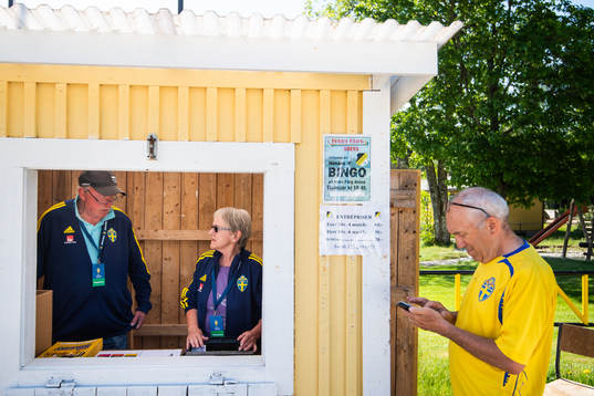 Två funktionärer och en besökare vid entrén