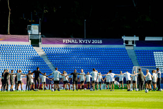 Players and staff of Wolfsburg gather in a circle