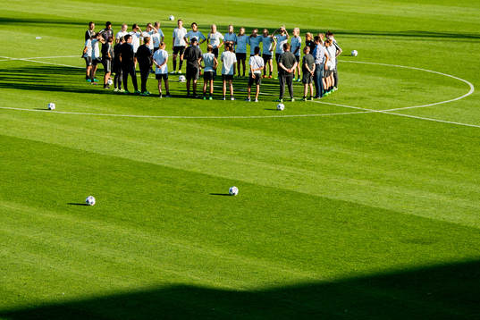 Players and staff of Wolfsburg gather in a circle