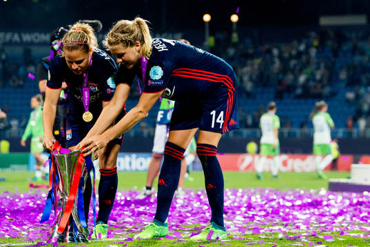 Eugénie Le Sommer and Ada Hegerberg of Lyon with the trophy