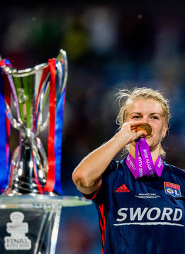 Ada Hegerberg of Lyon celebrates next to the trophy