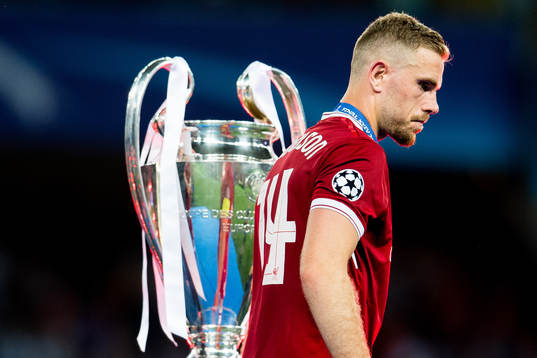 Jordan Henderson of Liverpool walks dejected past the trophy