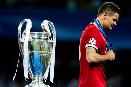 Dejan Lovren of Liverpool walks dejected past the trophy