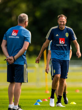 Andreas Granqvist skrattar och tittar på förbundskapten