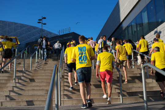 Ett svenskt fan går på väg till Friends Arena med en