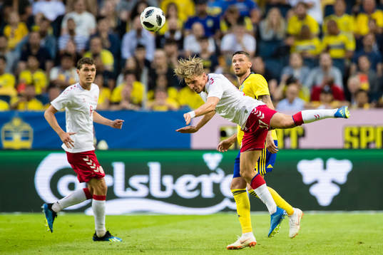 Danmarks Jens Stryger Larsen rensar undan bollen framför