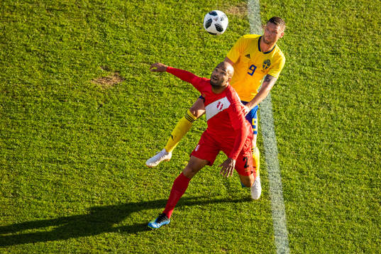 Albert Rodriguez of Peru competes for the ball with Marcus