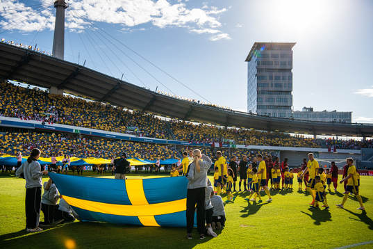 A Swedish flag in the foreground as the teams enter the