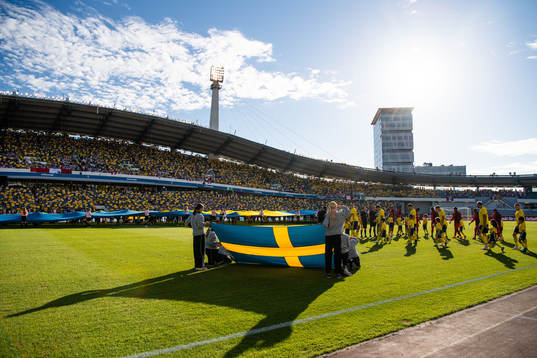 A Swedish flag in the foreground as the teams enter the