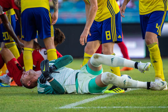 Goalkeeper Robin Olsen of Sweden reaches for his shoulder