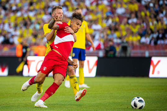 Paolo Guerrero of Peru competes for the ball with Sebastian