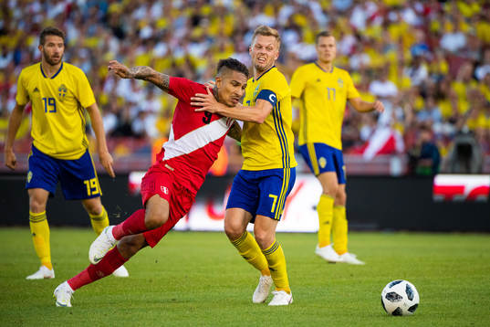 Paolo Guerrero of Peru competes for the ball with Sebastian