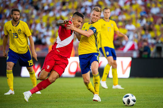Paolo Guerrero of Peru competes for the ball with Sebastian
