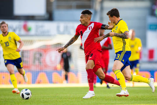 Paolo Guerrero of Peru competes for the ball with Victor