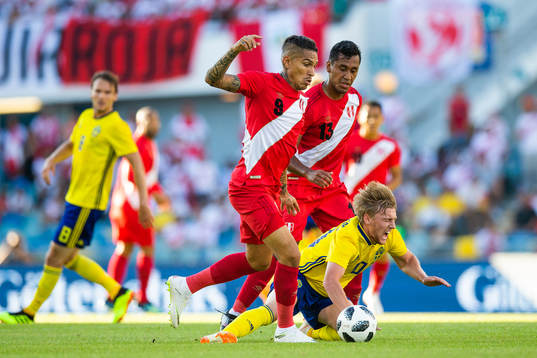 Paolo Guerrero and Renato Tapia of Peru competes for the