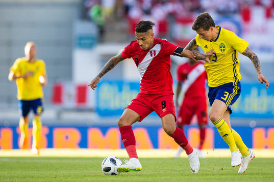 Paolo Guerrero of Peru competes for the ball with Victor