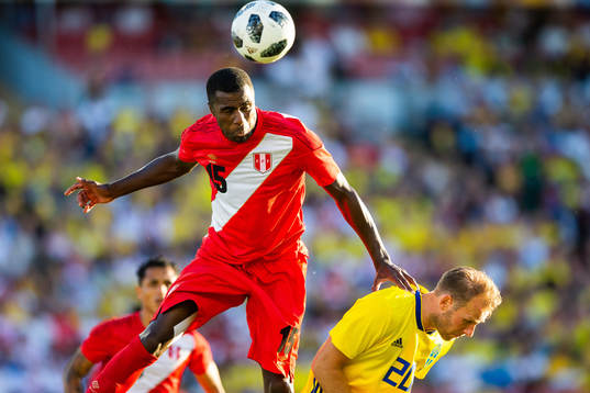 Christian Ramos of Peru wins a header against Ola Toivonen