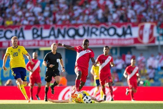 Luis Advincula of Peru avoids a tackle from Albin Ekdal of