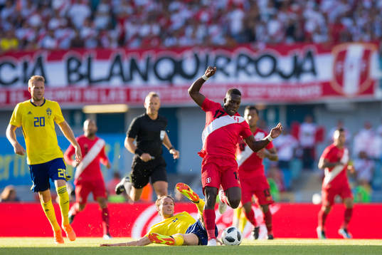 Luis Advincula of Peru avoids a tackle from Albin Ekdal of