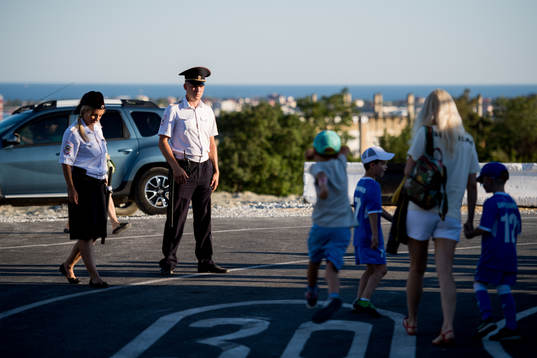 Russian security personnel watch spectators arriving to a