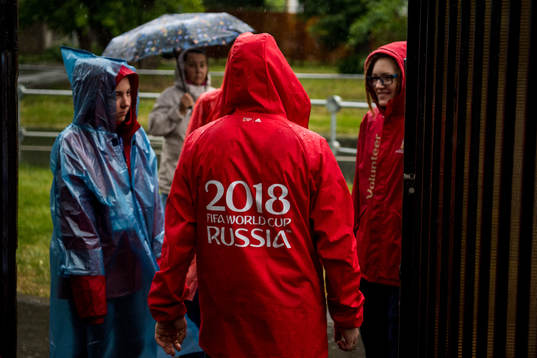 Volunteers is seen in the heavy rain prior team Mexico