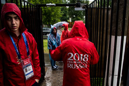 Volunteers is seen in the heavy rain prior team Mexico
