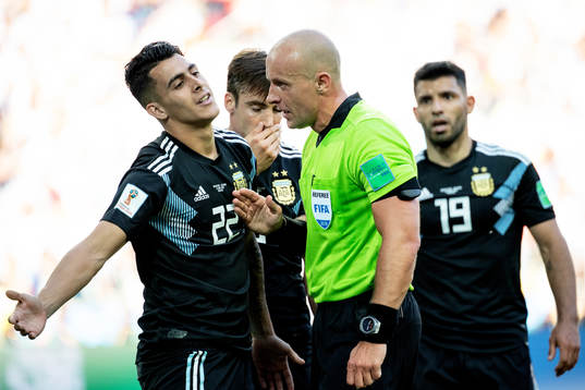 referee Szymon Marciniak talks to Cristian Pavon of