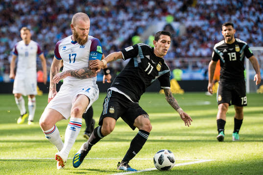 Aron Gunnarsson of Iceland in action with Angel Di Maria of