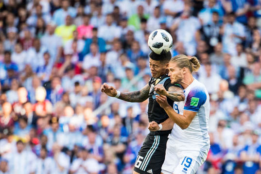 Marcos Rojo of Argentina in action with Rurik Gislason of