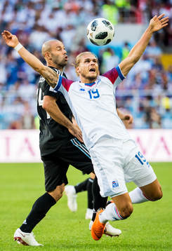 Rurik Gislason of Iceland and Javier Mascherano of Argentina