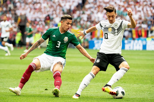 Carlos Salcedo of Mexico and Mesut Özil of Germany