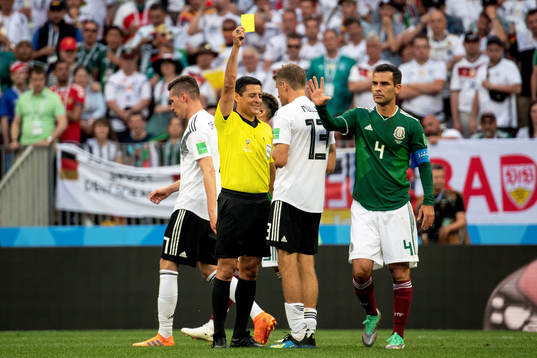 Thomas Müller of Germany is shown a yellow card by referee