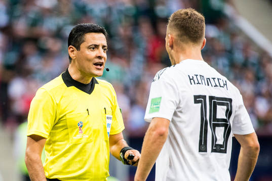 Referee Alireza Faghani talks to Joshua Kimmich of Germany