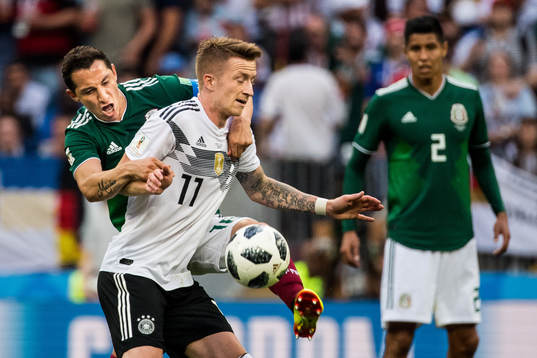 Marco Reus of Germany in action with Andres Guardado of