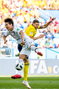 Younggwon Kim of South Korea and Marcus Berg of Sweden