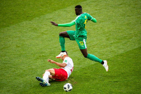 Thiago Cionek of Poland and Mbaye Niang of Senegal
