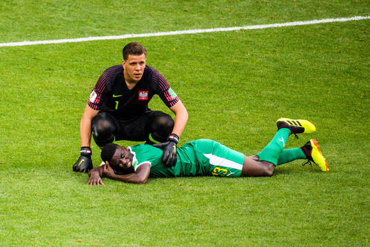 Alfred Ndiaye of Senegal in pain next to goalkeeper