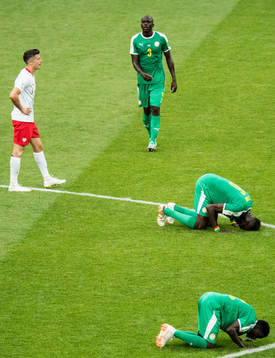 Robert Lewandowski of Poland looks dejected and players of