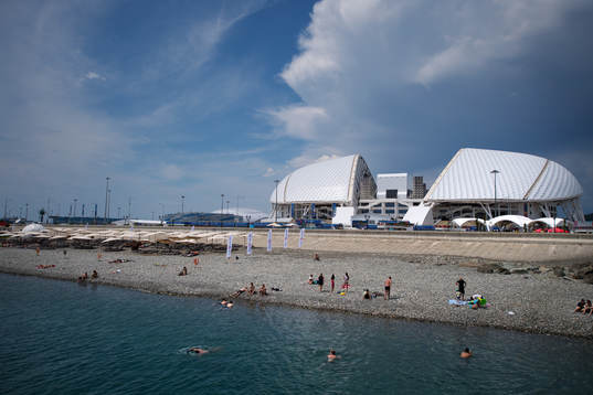 People bathing in front of Fisht Stadium