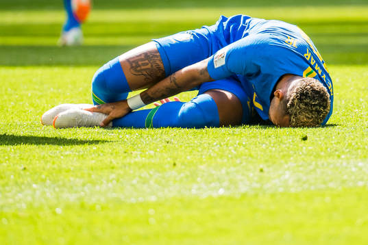 Neymar of Brazil lies down with an injury