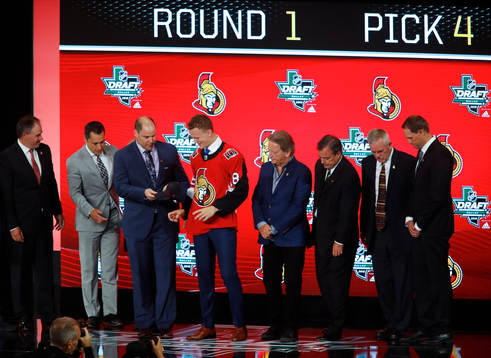 Brady Tkachuk poses with team representatives
