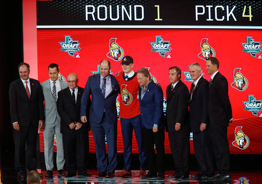 Brady Tkachuk poses with team representatives