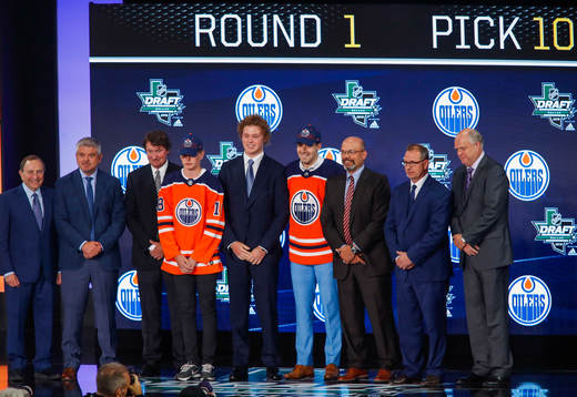Evan Bouchard of Canada poses with team representatives