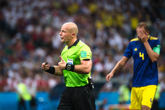referee Szymon Marciniak and Andreas Granqvist of Sweden