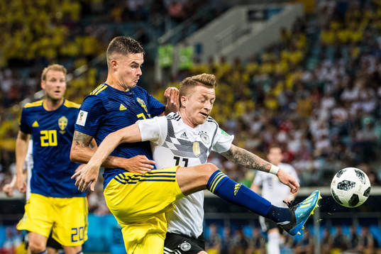 Mikael Lustig of Sweden in action with Marco Reus of Germany