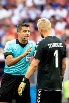 referee Sandro Ricci and goalkeeper Kasper Schmeichel of