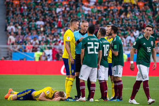 Mikael Lustig of Sweden with Referee Nestor Pitana