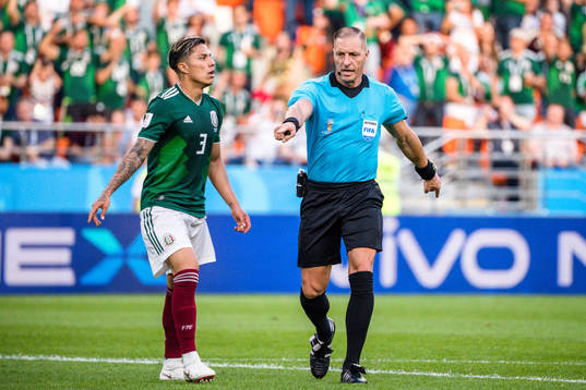 Carlos Salcedo of Mexico looks dejected next to Referee