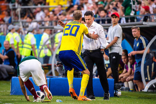 Ola Toivonen of Sweden collides with Head coach Juan Carlos