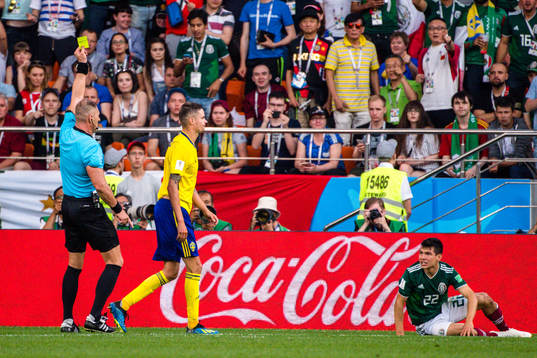 Mikael Lustig of Sweden receives a yellow card